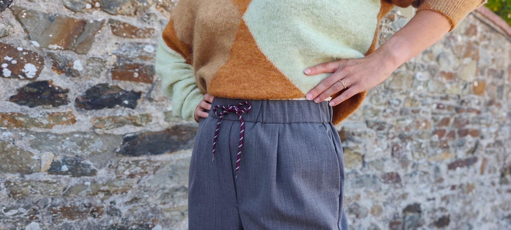 Pull en maille camel et vert d’eau porté au-dessus des toits de Granville