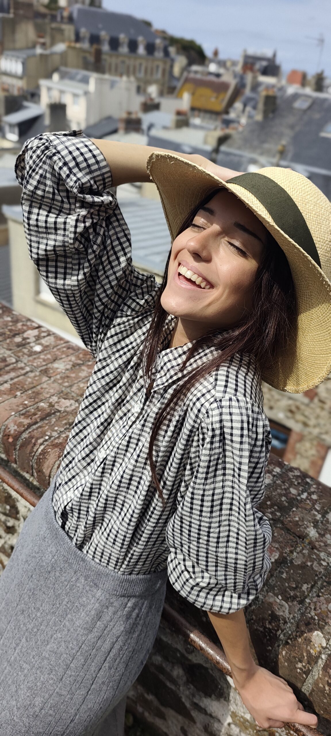 Chemise à carreaux noir et blanc, jupe grise et chapeau de paille sur les hauteurs de Granville